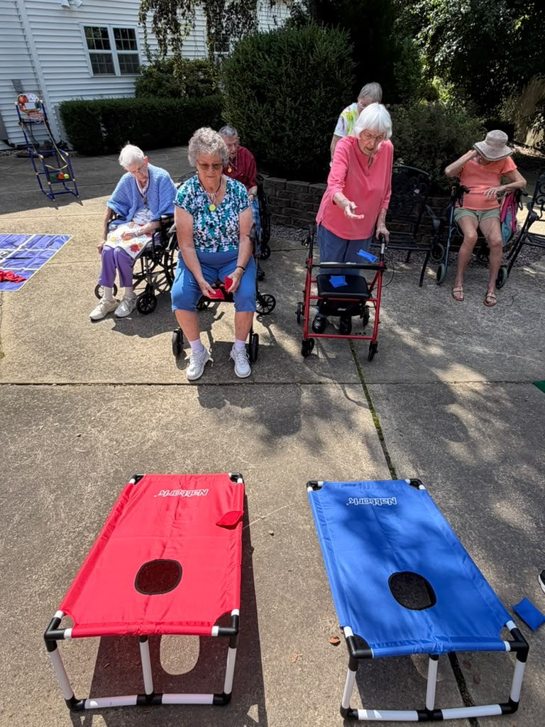 Residents playing cornhole outdoors at Prairie Gardens