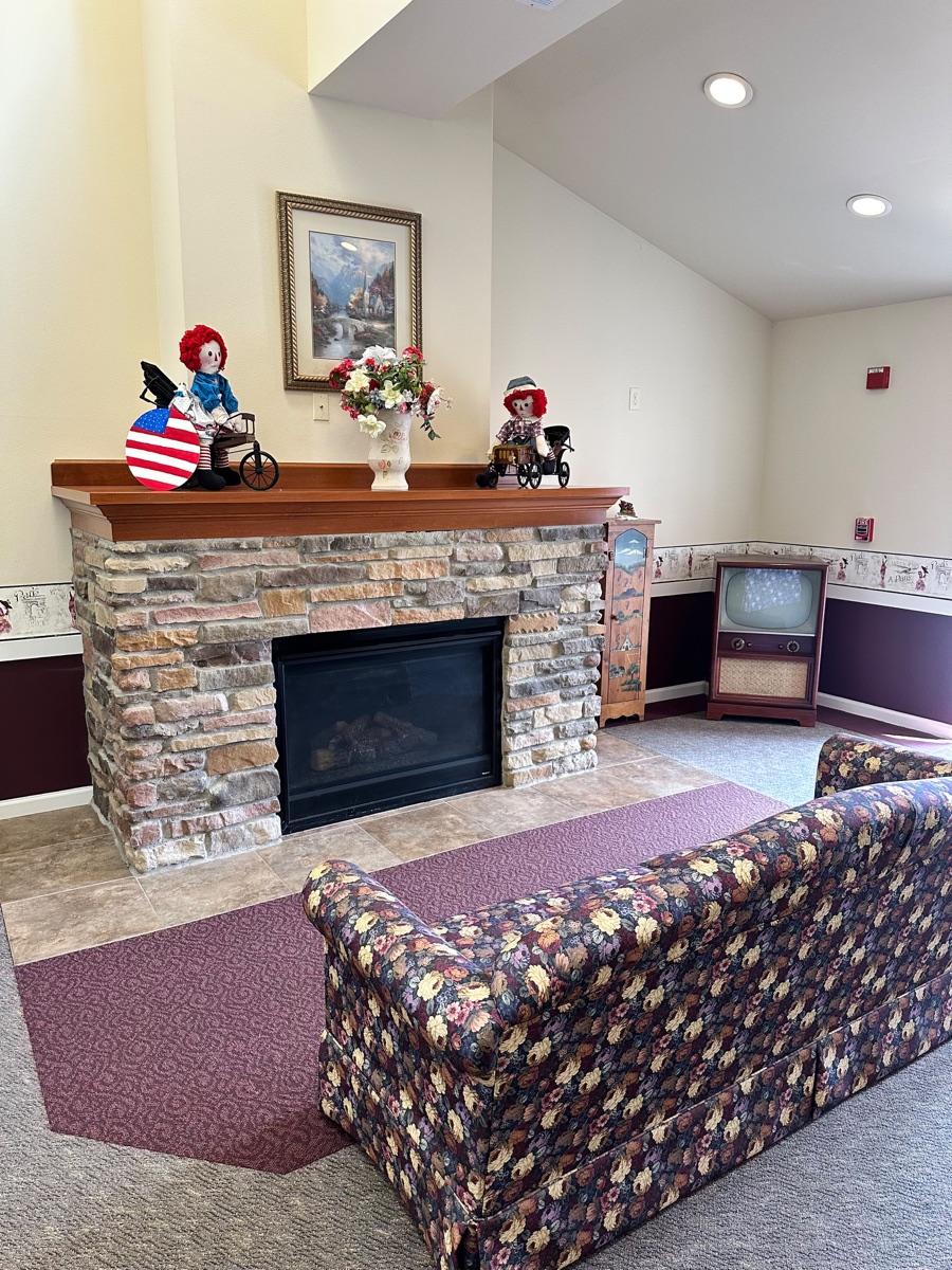 Cozy common area with stone fireplace at Prairie Gardens